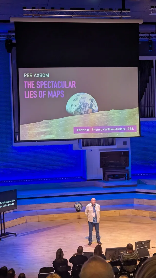 Foto: James Winstone: Per Axbom på scen på Camp Digital 2025. Inledande bild: The Spectacular Lies of Maps, med fotot Earthrise.